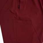 A close-up view of maroon fabric showing a square patch pocket and a small black Addos tag with red text.