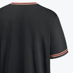 Close-up of the back of a black jersey showing the neckline and sleeve cuff with red and gold striped trim.
