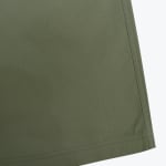 Close-up of olive green ripstop fabric with a double-stitched hem and side seam.