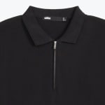 Close-up of a black polo shirt with a silver quarter-zip and a classic collar.
