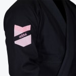 Close-up of a black martial arts gi sleeve featuring a pink and white embroidered Addos logo patch.