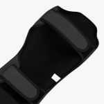 Close-up of the inner lining and velcro straps of a black martial arts shin guard.