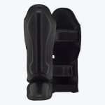 A pair of black leather shin guards showing the front padded shield and the back fastening straps against a white background.