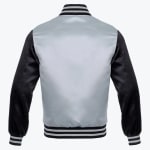 Back view of a silver and black satin varsity jacket with striped ribbed collar, cuffs, and hem against a white background.