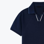Close-up of a navy blue polo shirt with a buttonless V-neck collar featuring white and light blue trim details.