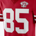 Close-up of a red San Francisco 49ers football jersey with the number 85 in white and a 75th-anniversary patch on the chest.