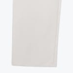 Close-up of the stitched hem of a light grey fabric trouser leg showing its woven texture.