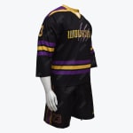 A black sports uniform with purple and gold accents, including a jersey with the word WOLVERINES slashed by claw marks and the number 23, paired with matching black shorts, shown on a white mannequin.