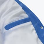 Close-up of the white inner lining and a blue-trimmed interior pocket of an Addos jacket.