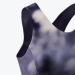 Close-up of a dark blue and white tie-dye sports bra with wide straps against a clean white background.