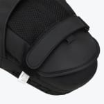 Close-up view of the back of a black boxing focus mitt showing the adjustable wrist strap, mesh hand compartment, and padded finger cover.