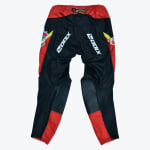 Back view of black and red Zodix motocross pants with Akrapovič logo on the waistband and reinforced knee patches.
