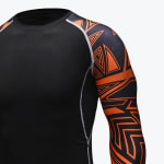 Close-up of a black long-sleeve compression shirt with an orange and black geometric pattern on the sleeve and grey flatlock stitching.