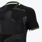 Close-up of a black athletic jersey with a dark grey geometric pattern, featuring a green and white trim on the collar and sleeve cuff.