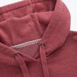 Close-up view of a maroon heathered hoodie showing the hood, drawstrings, and patterned inner collar tape.