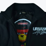 Close-up of a black Urbano All Stars jacket unzipped to show a cartoon bear graphic lining inside.