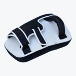 A black and white Muay Thai forearm kick pad with a sturdy handle and two adjustable straps on a plain white background.
