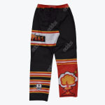 A pair of black, red, and yellow Anchor Hockey roller hockey pants featuring a cartoon mushroom cloud explosion graphic on one leg and striped patterns with an anchor logo on the other.