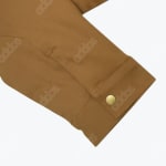 Close-up of a brown Addos jacket sleeve cuff with a repeating logo pattern and a gold snap button.