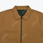 Close-up of a brown canvas work jacket with a zipper, collar, and chest pocket.