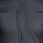 Close-up of a dark grey ripstop fabric jacket showing a central zipper flap with an angular design.