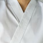 Close-up of the collar and lapel of a white martial arts uniform with detailed stitching.