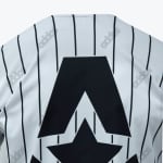 Close-up of a white pinstriped Addos shirt featuring a large black stylized A and star graphic on the back.