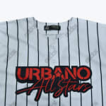 Close-up of a white pinstriped baseball jersey with brand text printed in red and black on the chest.