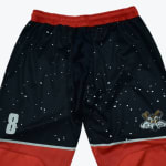 A pair of black basketball shorts with a starry space design, a red waistband, red lower panels, the number 8 on one leg, and a Tasmanian Devil cartoon face on the other.