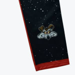 Close-up of black pants featuring a starry pattern, red trim, and an angry Wile E. Coyote graphic.