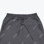 Close-up of dark grey Addos sweatpants showing the elastic waistband, drawstring, pockets, and subtle all-over logo pattern.