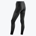 Rear three-quarter view of black technical athletic leggings with multi-textured panels and a zippered pocket on the back waistband.