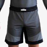 A person wearing grey and black athletic shorts with a black elastic waistband and a matching grey compression shirt.