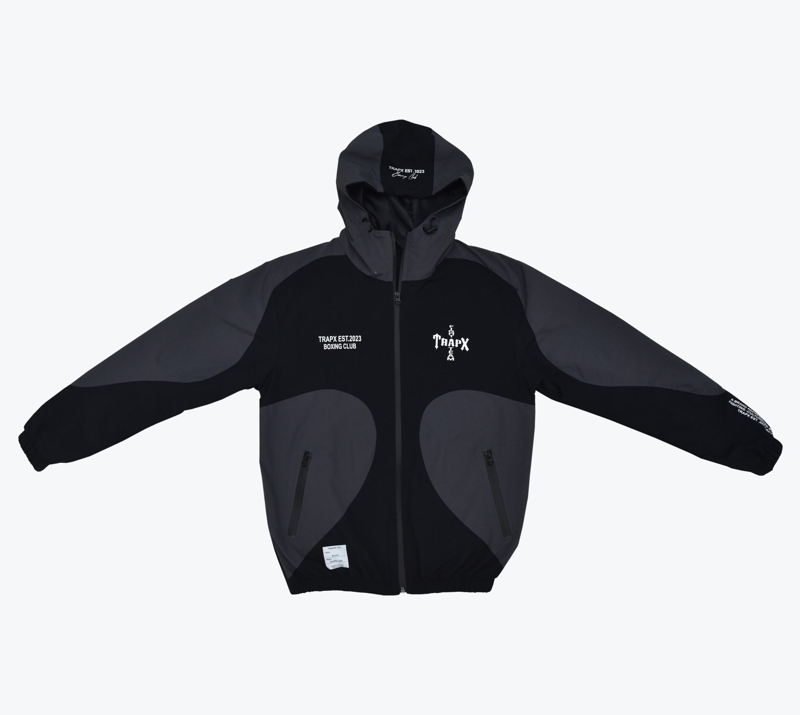 A black and grey hooded zip-up jacket with TRAPX EST.2023 BOXING CLUB printed on the chest.