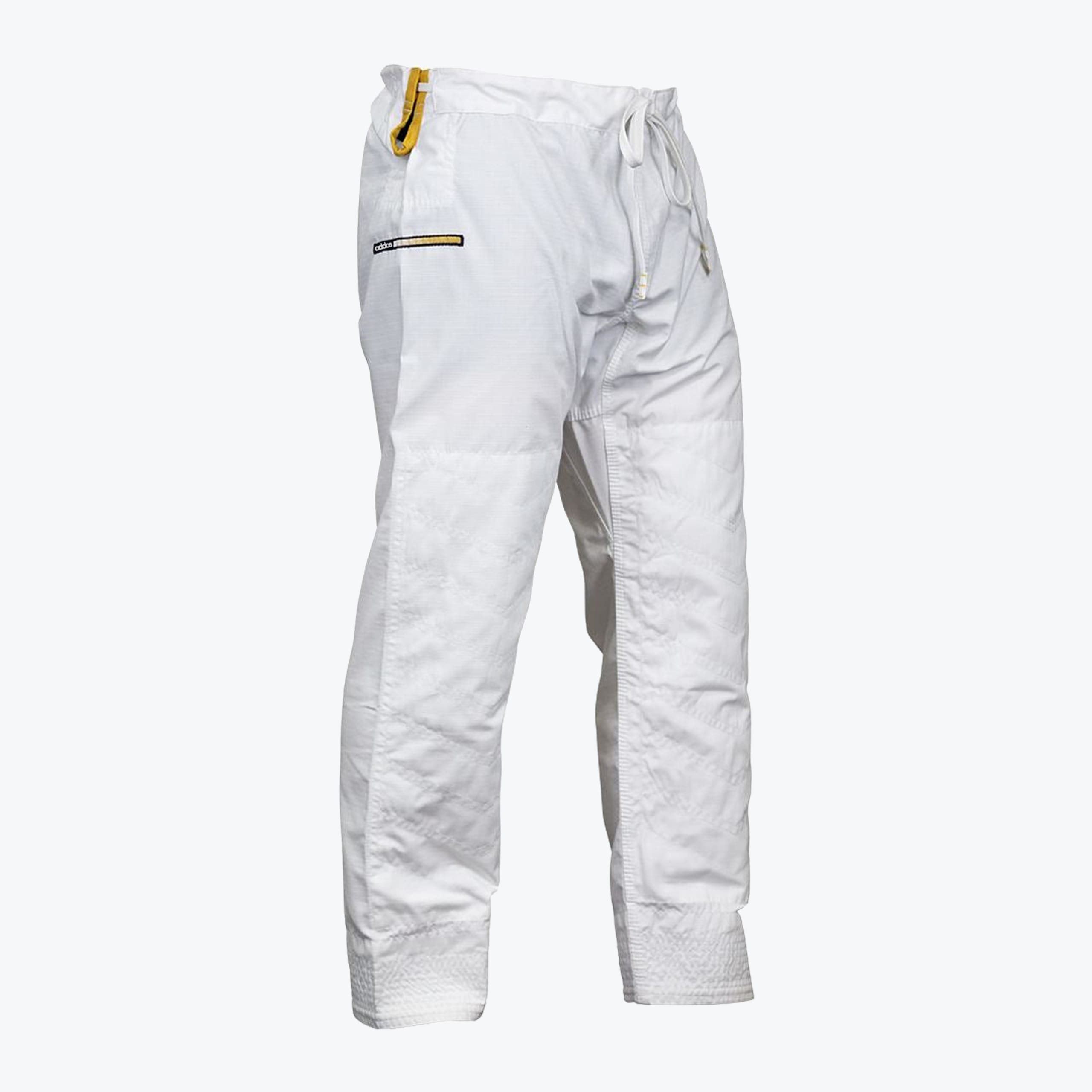A side-angle product shot of white Addos Jiu-Jitsu gi pants with gold accents, isolated on a white background.