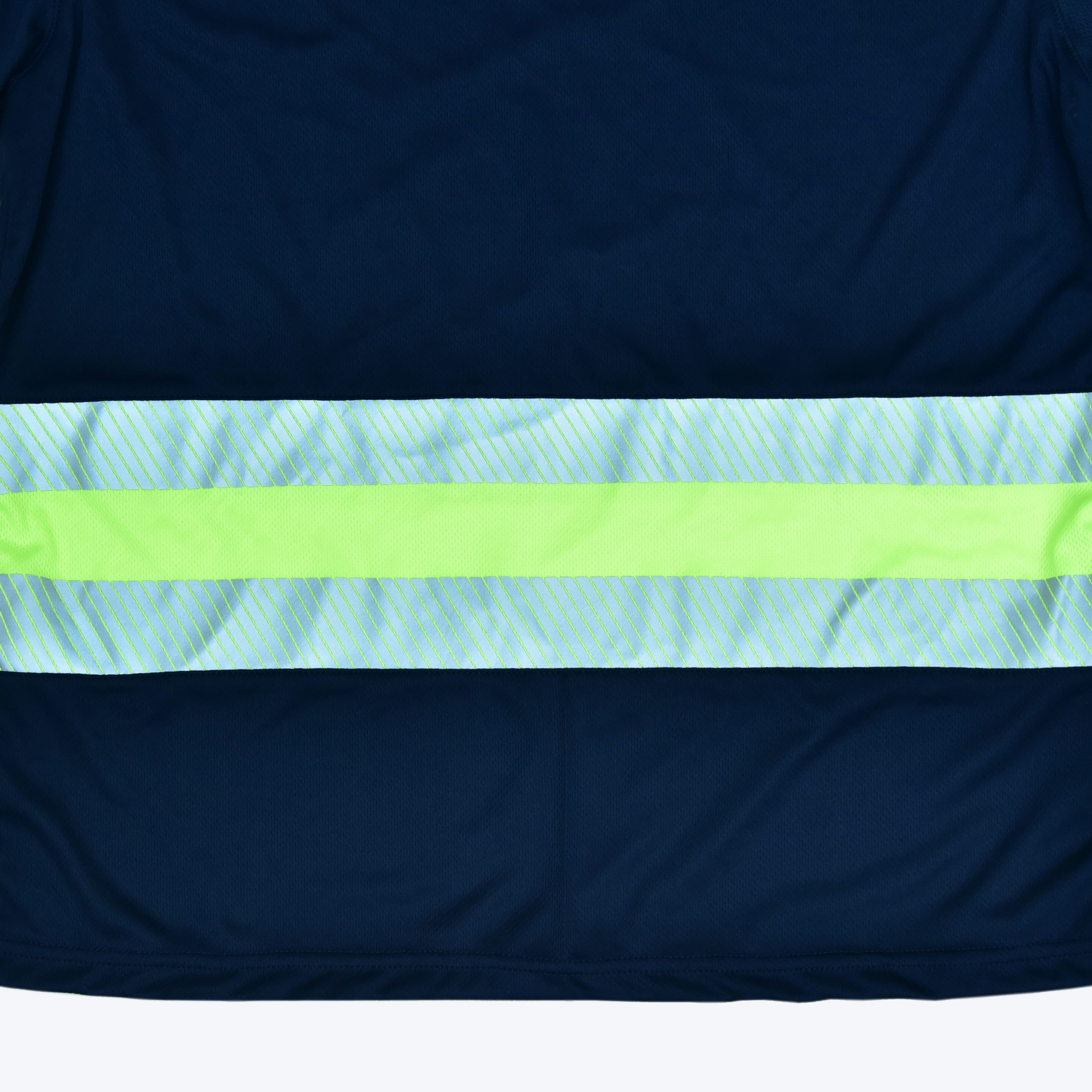 Close-up of a navy blue safety garment showing a horizontal reflective band with a lime green stripe in the middle and silver diagonal-striped reflective tape on the top and bottom.