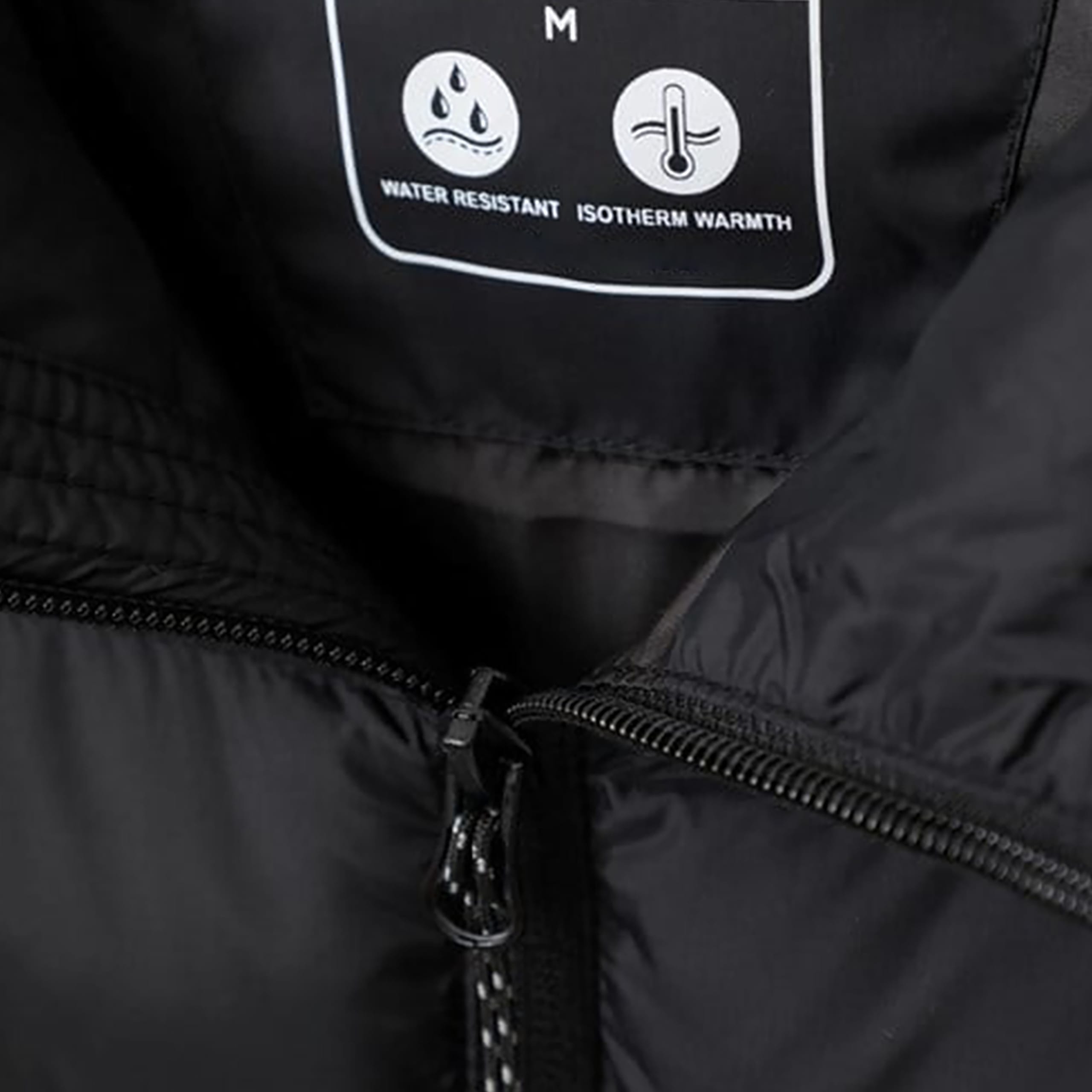 Close-up of a black jacket interior label showing size M, water resistant and isotherm warmth icons, and a partially open zipper.