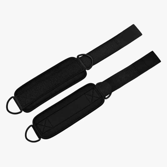 A pair of black padded ankle straps with adjustable velcro fasteners and metal D-rings, displayed on a plain white background.