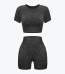 A two-piece dark grey mineral wash activewear set consisting of a short-sleeve crop top and high-waisted shorts, displayed against a plain white background.