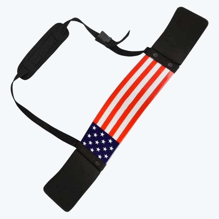 An arm blaster fitness accessory with an American flag design, black padded elbow rests, and an adjustable neck strap, isolated on a white background.