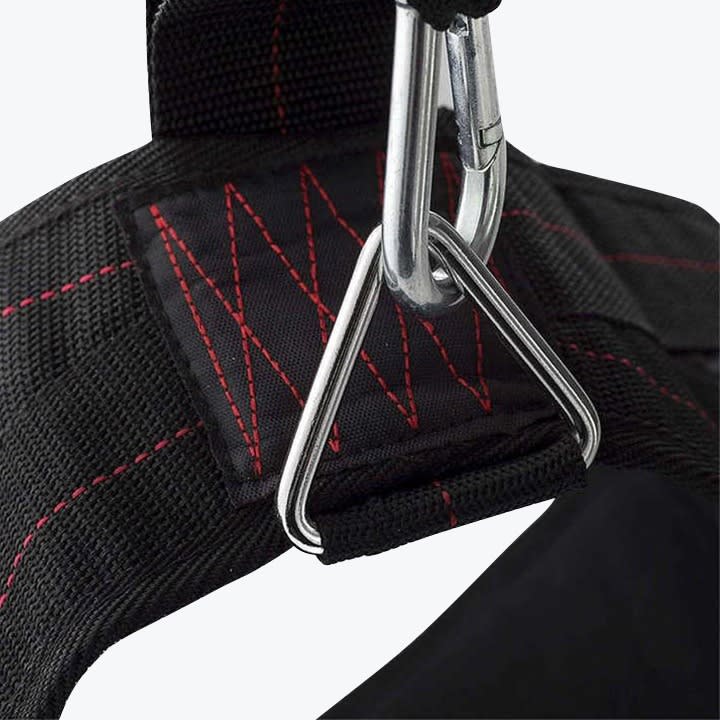 Close-up of a heavy-duty black strap with red reinforced stitching, a triangular metal ring, and a silver carabiner clip attached.