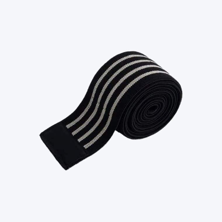 A rolled-up black elastic knee wrap with four parallel grey stripes on a white background.