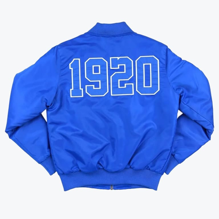 The back of a bright blue bomber jacket featuring the number 1920 in large white-outlined block letters against a solid white background.