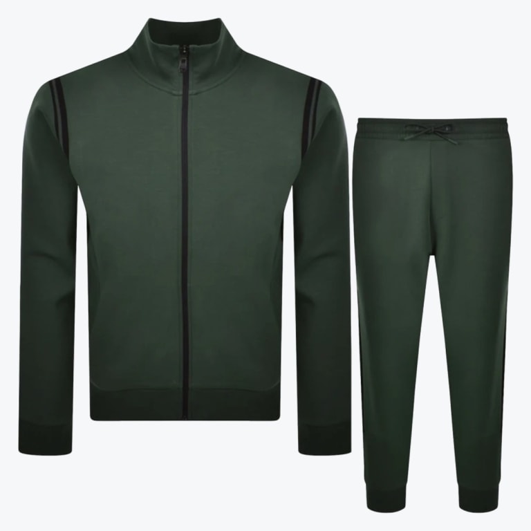 A two-piece dark green mens tracksuit consisting of a zip-up jacket with black shoulder stripes and matching drawstring jogger pants, displayed against a white background.