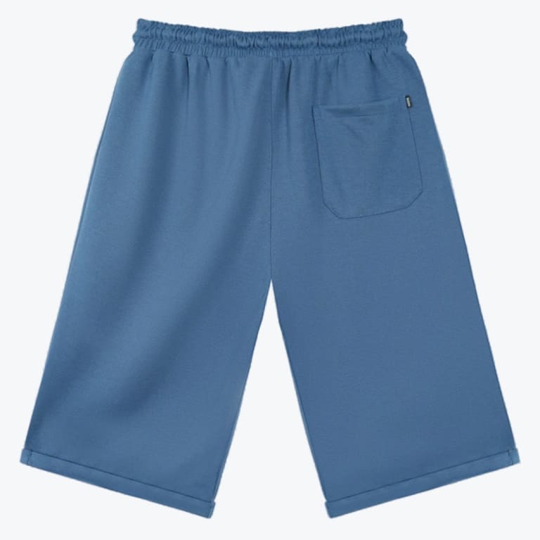 Back view of a pair of dusty blue casual sweat shorts with an elastic waistband and a single back pocket, isolated on a white background.