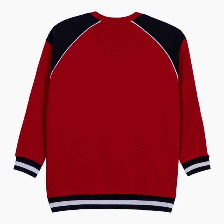 The back of a red crewneck sweatshirt featuring black raglan shoulders with white piping, and black-and-white striped ribbed cuffs and hem.