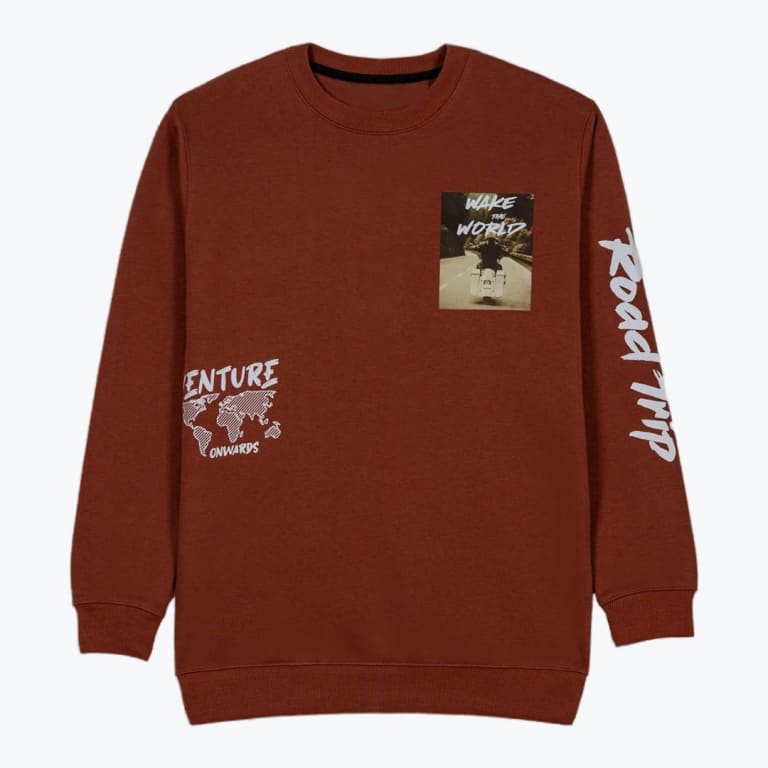 A rust-brown crewneck sweatshirt featuring a motorcycle graphic on the chest, a world map graphic on the lower left, and Road Trip printed on the sleeve.