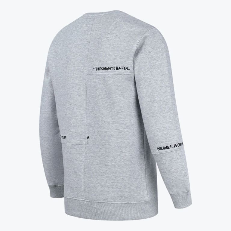 Back view of a light grey crewneck sweatshirt with black handwritten text graphics and paneled stitching.