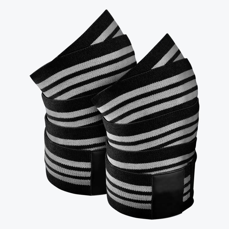 A pair of rolled-up black and white striped athletic knee wraps on a white background.