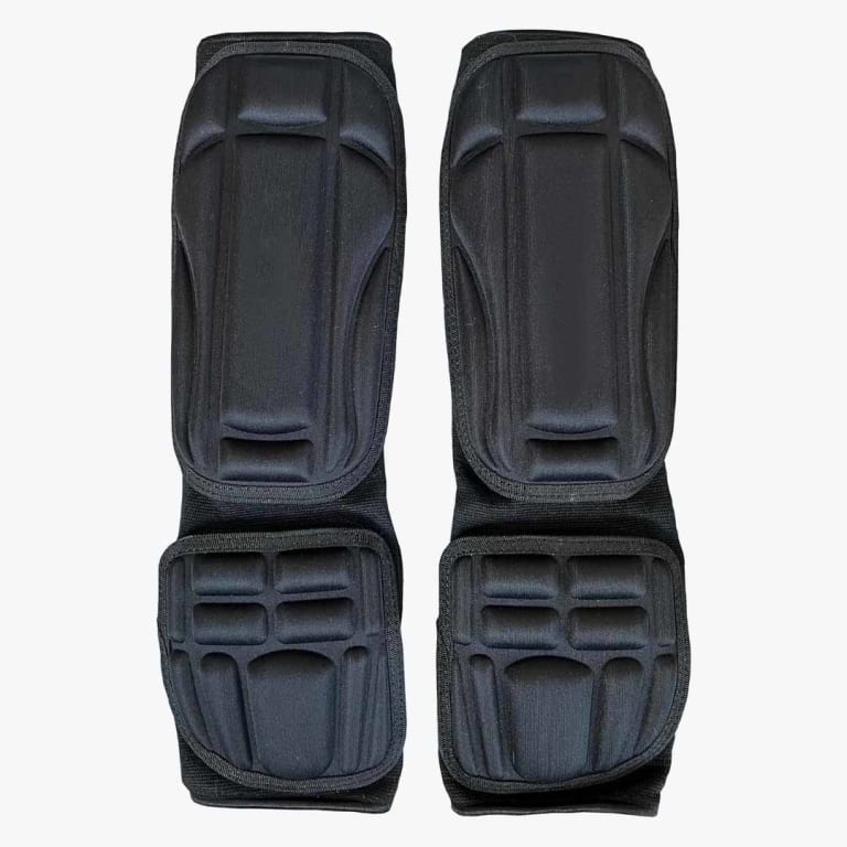 A pair of black elasticated shin and instep guards for martial arts, displayed against a white background.